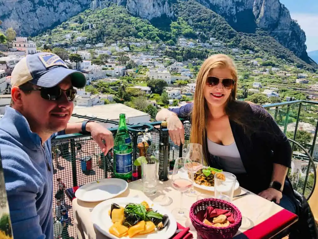 Pulalli Wine Bar in Capri - photo on the outside balcony overlooking the mountains and streets below. As an amalfi coast trip planner this is one of my favorite spots to eat.
