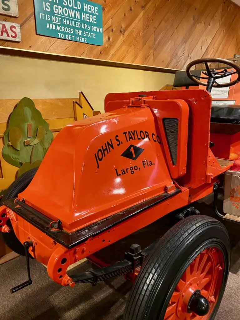 Photo is of a beautiful orange tractor from the citrus groves in Pinellas County.  Tractor is located in the indoor museum at Pinellas County Heritage Village Largo Florida 