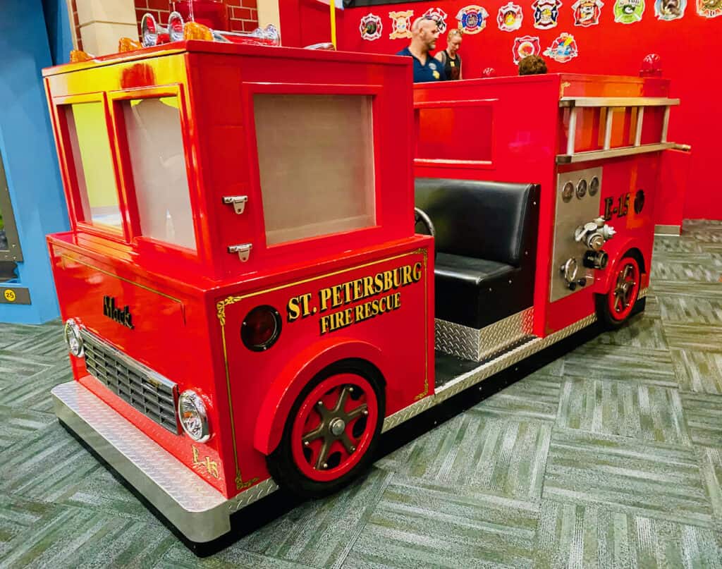 Big red fire truck at Great Explorations Children's Museum with flashing lights.