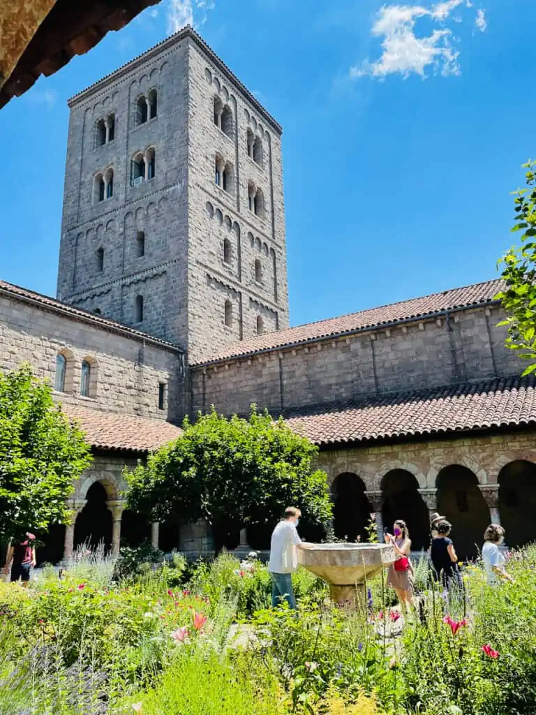 The Met Cloisters Museum gardens is beautiful with archways, flowers and trees.