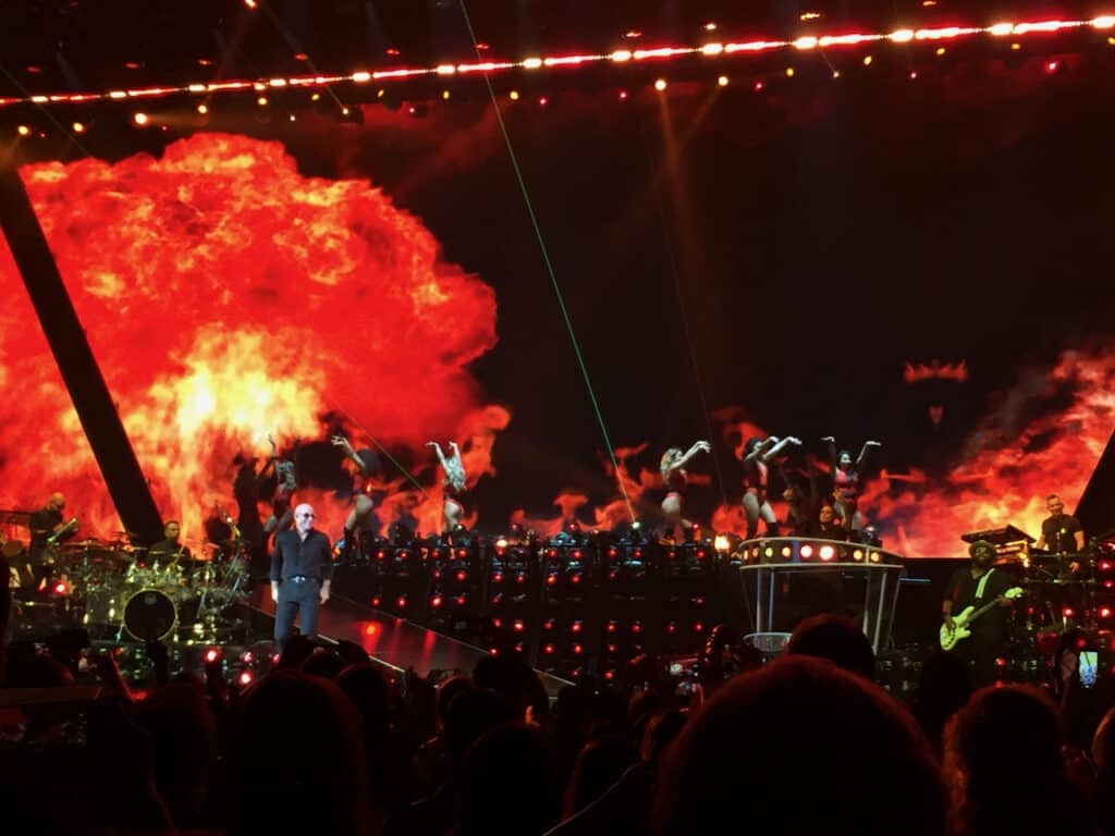 Flames and dancers fill the stage behind Pitbull at Amalie Arena. 