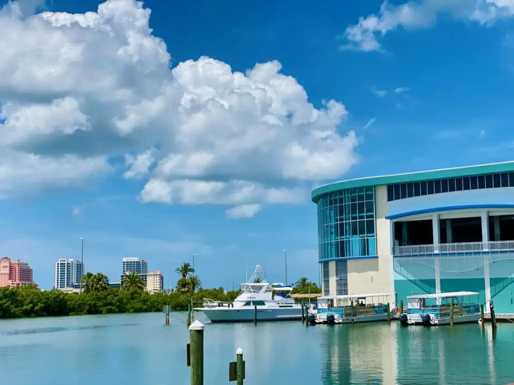 Waterview of the Clearwater Aquarium in Clearwater Beach.  Shows the boat tour boats and view of buildings in the distance near the beach.  