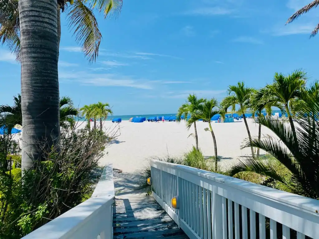Bellweather Beach Resort has the ideal location on St. Pete Beach with sugar white sand, palm trees, and a high rise building with a rotating restaurant at the top. Photo shows the gorgeous beach.