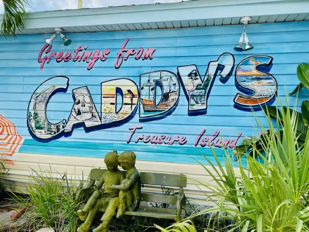 Photo of the front of Caddy's with a sign that reads "Greetings from Caddy's Treasure Island" 