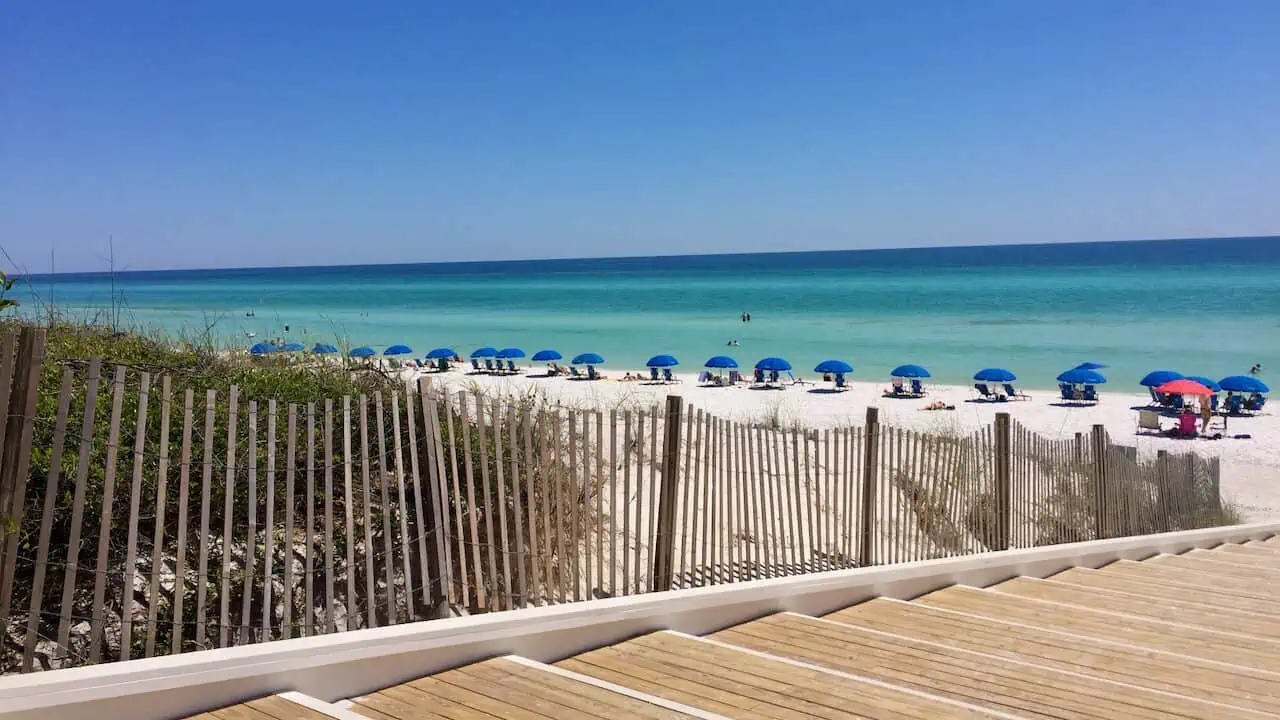 Seaside Beach Access in Seaside Florida.  Beautiful blue cabanas in the distance sitting next to the turquoise water.