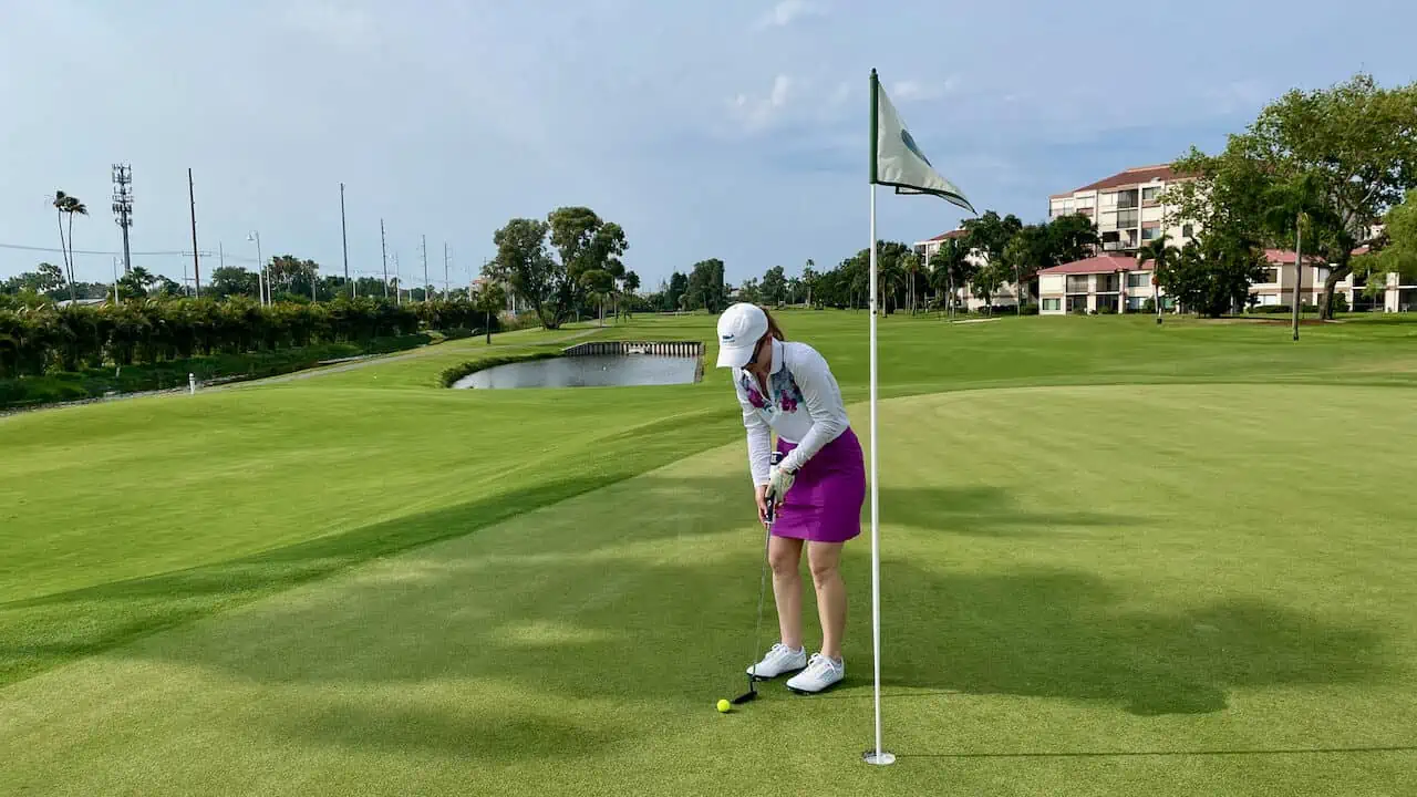Erin golfing in Florida; putting on green. 