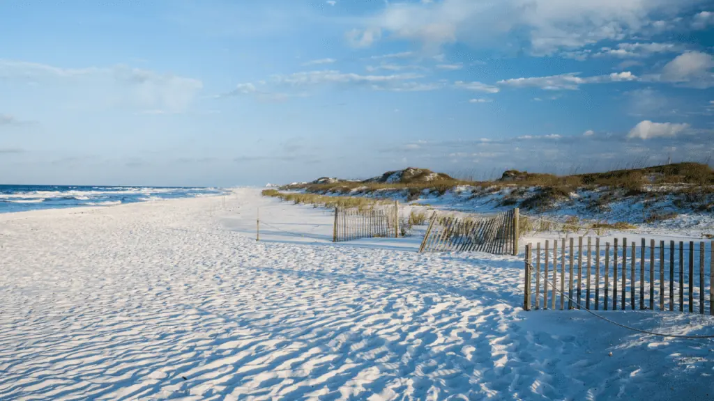 Grayton Beach with beautiful sand dunes and fence along the shore.