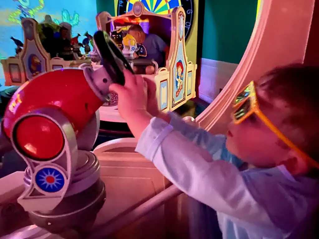 on the toy story mania ride with toddler driving the car