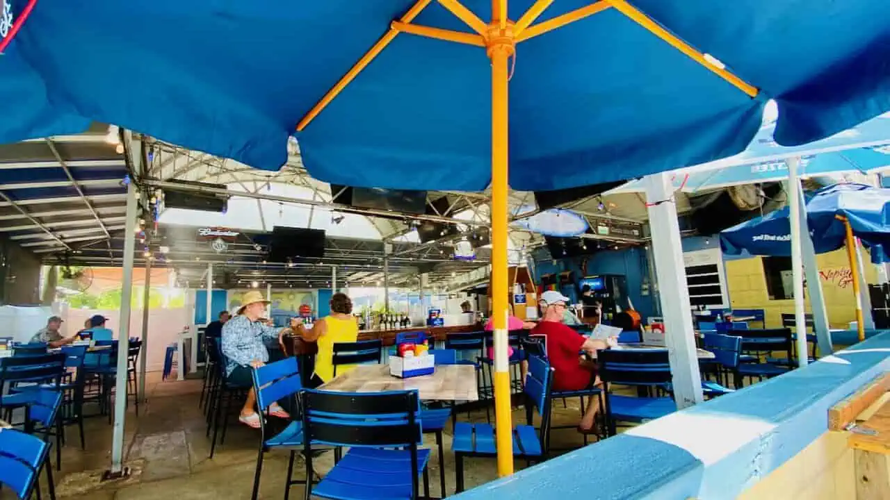 Outdoor dining and bar at Neptune Grill in Gulfport Florida.  This is one of the best bars for volleyball and beach views. 